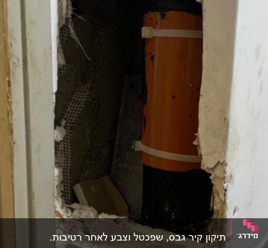 צינור כתום בקיר פתוח עם תיקון טיח